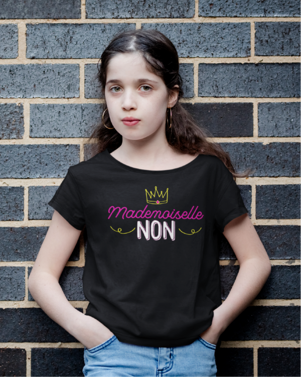 Sur cette image on peut voir un t-shirt personnalisé "Mademoiselle non" avec une couronne. Ce t-shirt enfant est personnalisé au sein de notre boutique qui se situe à Caissargues à coté de Nîmes dans le Gard.
