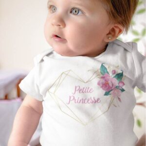 Sur cette image on peut voir un body personnalisé "Petite princesse" dans un cœur avec des fleurs. Il est imprimé au sein de notre boutique l'usine du t-shirt Caissargues dans le Gard.