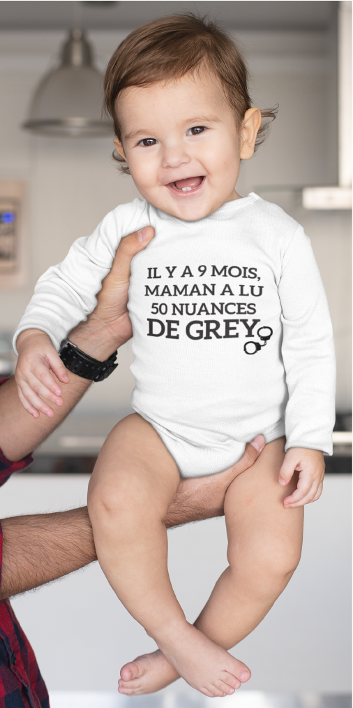 Sur cette image on peut voir un body personnalisé "Il y a 9 mois maman a lu 50 nuances de Grey" avec une paire de menottes. Il est imprimé au sein de notre boutique l'usine du t-shirt à Caissargues dans le Gard.