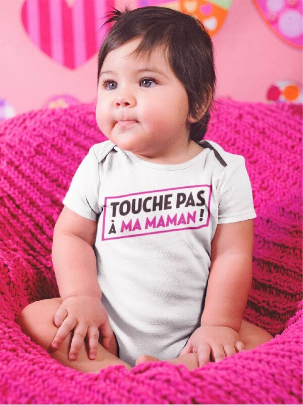 Sur cette image on peut voir un body personnalisé "Touche pas à ma maman". Il est imprimé au sein de notre boutique l'usine du t-shirt à Caissargues dans le Gard.