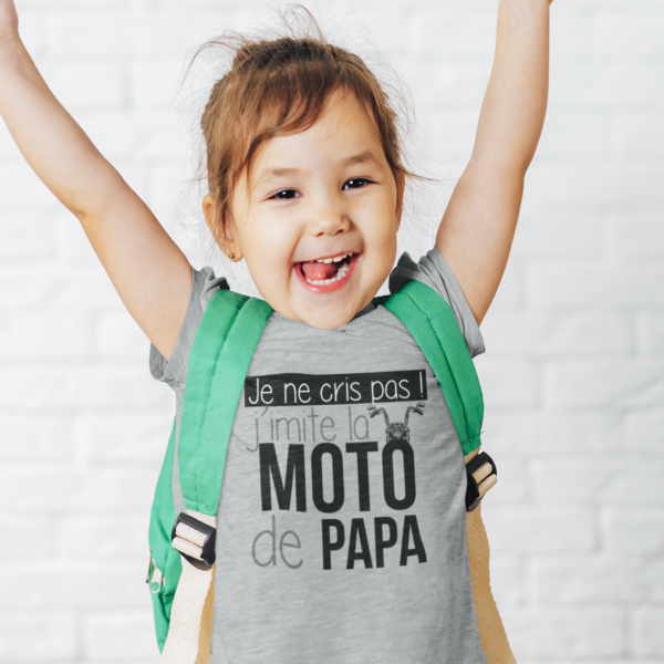 Sur cette image on peut voir un t-shirt enfant personnalisé "Je ne cris pas j'imite la moto de papa" avec l'image d'une moto. Il est imprimé au sein de notre boutique qui se trouve à Caissargues à coté de Nîmes dans le Gard