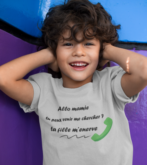 Sur cette image on peut voir un t-shirt enfant personnalisé "Allo mamie tu peux venir me chercher ? Ta fille m'enèrve." Il est imprimé au sein de notre boutique qui se trouve à Caissargues à coté de Nîmes dans le Gard.