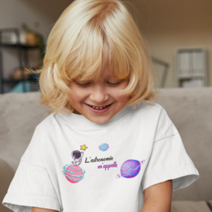 Sur cette image on peut voir un t-shirt enfant personnalisé "L'astronomie m'appelle" avec des images de planètes, étoiles et astronautes. Il est imprimé au sain de notre boutique qui se trouve à Caissargues à coté de Nîmes dans le Gard.